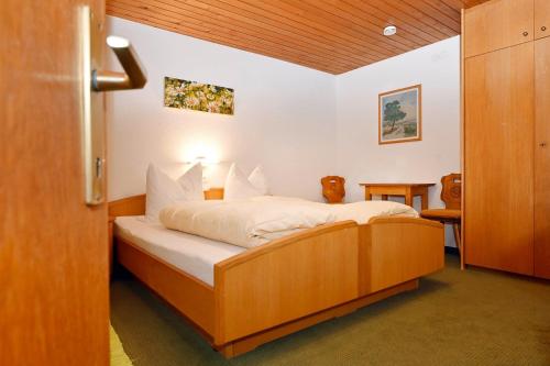 a bedroom with a bed with white sheets at Rundblick 2 Gartenwohnung in Tschagguns