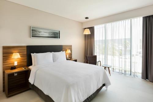 a hotel room with a bed and a large window at Fiesta Inn Express Cancún Cumbres in Cancún