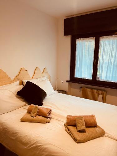 a bed with two towels sitting on top of it at Il Cadorino in Valle di Cadore