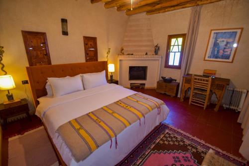 ein Schlafzimmer mit großem Bett und Kamin in der Unterkunft Bluegreen Guest House Marrakech in Aït Amara