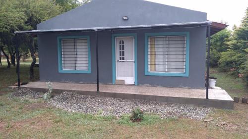 ein kleines blaues Haus mit einer weißen Tür in der Unterkunft Los Peñi in Cortaderas