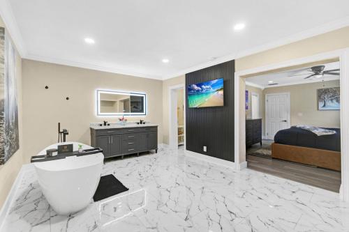 Un baño grande con bañera y cama. en RJ Home Away From Home LLC, en Miami Gardens