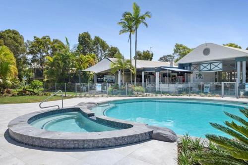 einen Pool in einem Hof mit einem Gebäude in der Unterkunft Gorgeous Apartment in Luxurious Noosa Resort in Noosaville
