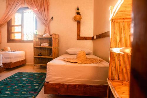 Un dormitorio con dos camas y una ventana. en Surf Away Morocco, en Agadir