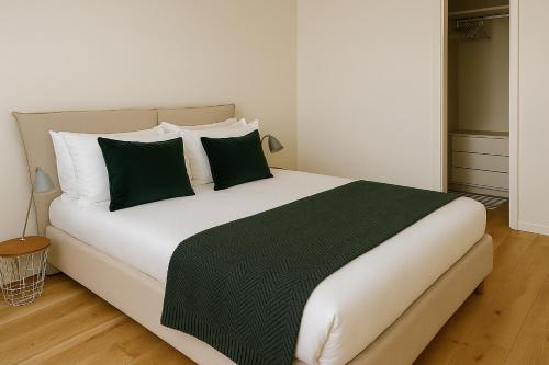 a bedroom with a large bed with green and white pillows at Adorable Apartment City Center with Parking, Near Tram in Luxembourg