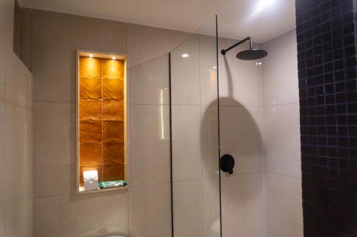 una ducha con puerta de cristal en un baño en Hotel y Restaurante Mesón del Gitano, en Caucasia