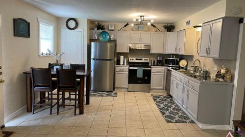 eine Küche mit einem Kühlschrank sowie einem Tisch und Stühlen in der Unterkunft Broadview Lovely Apt Close to Beaches in Freeport
