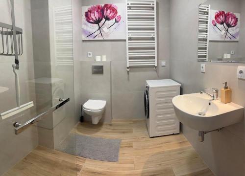 a bathroom with a white sink and a toilet at Panorama Biegusa 74 in Gliwice