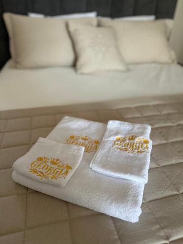 two towels sitting on top of a bed at Georgia Suites in Lyubimets