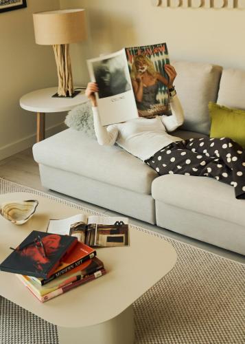 a woman sitting on a couch reading a book on a coffee table at Hotel Circulo in Charleston