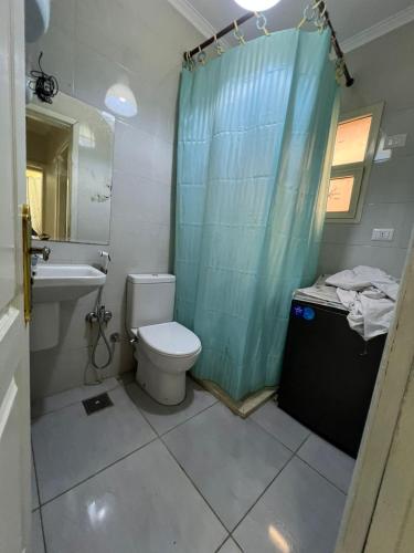 Un baño con inodoro, lavabo y ducha. en متاحه الان شقه ف المستقبل غرفتين نوم حمام مطبخ ريسبنش واي فاي, en Sheikh Zayed