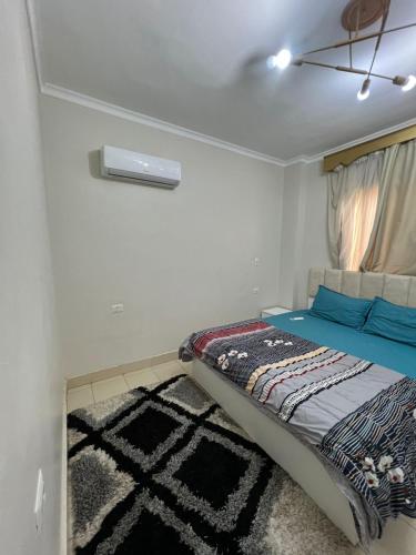 Un dormitorio pequeño con una cama y una ventana. en متاحه الان شقه ف المستقبل غرفتين نوم حمام مطبخ ريسبنش واي فاي, en Sheikh Zayed
