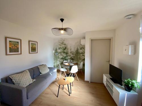 ein Wohnzimmer mit Sofa und Tisch in der Unterkunft Cosy appartement proche saint emilion in Le Fieu