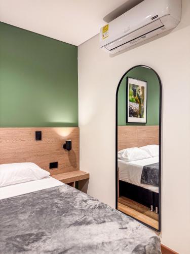 a bedroom with a bed and a mirror at Habitat Ochentayuno in Medellín