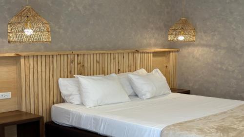 - une chambre avec un lit doté d'oreillers blancs et de deux lumières dans l'établissement Hotel Blue Cove by On vacation, à San Andrés
