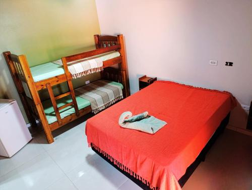 a room with two bunk beds and a red blanket at Casa Recanto de Brotas suítes para família e grupos de amigos in Brotas
