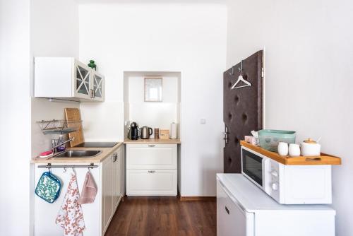 eine kleine Küche mit weißen Schränken und einer Spüle in der Unterkunft Tiny apartment in a family house apartment near the center in Nový Jičín