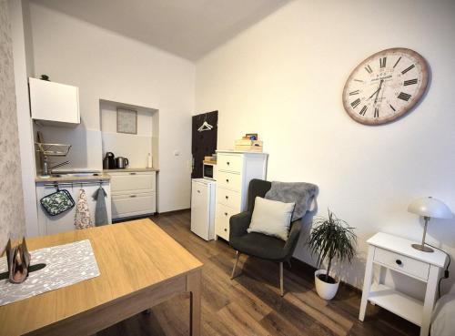 Zimmer mit einem Tisch und einer Uhr an der Wand in der Unterkunft Tiny apartment in a family house apartment near the center in Nový Jičín