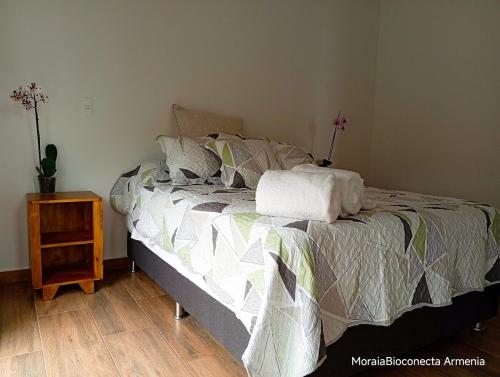 a bedroom with a bed and a nightstand with a bed sidx sidx at Moira Ecolodge - Armenia Laureles in Armenia