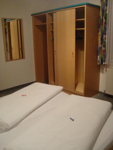 a room with a bed and a closet with white sheets at Ferienwohnung Moritz in Kaunertal