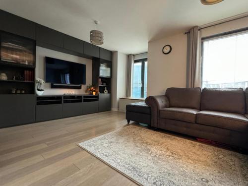 a living room with a couch and a flat screen tv at Salt House, Stunning Swansea Marina Townhouse Sleeps 12, Beach & Arena in Swansea