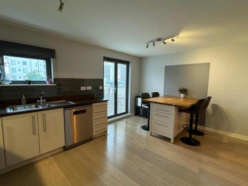 an empty kitchen with a desk and a table at Salt House, Stunning Swansea Marina Townhouse Sleeps 12, Beach & Arena in Swansea