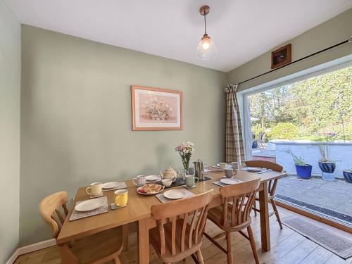 ein Esszimmer mit Tisch und Stühlen und einem Fenster in der Unterkunft Brithdir in Leighton