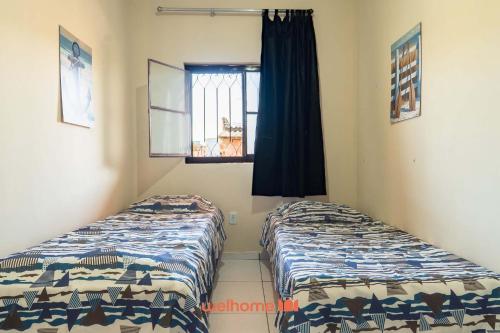 zwei Betten in einem Zimmer mit Fenster in der Unterkunft Casa em Cabo Frio com Churrasqueira e Praia in Barra de São João
