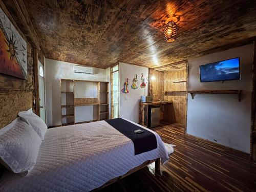 a bedroom with a bed and a tv on the wall at Hotel Habitare mini in Aguascalientes