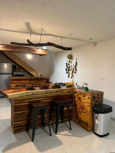 a kitchen with a wooden counter with stools in it at Hotel Habitare mini in Aguascalientes