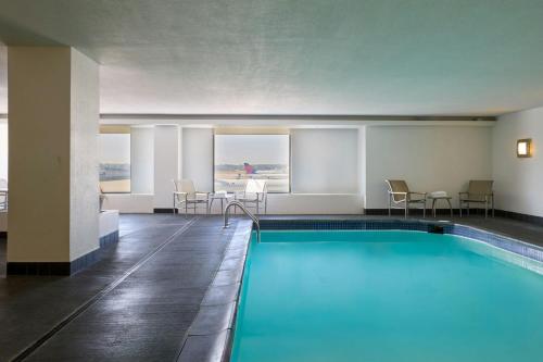 a pool in a hotel room with chairs and a table at The Westin Detroit Metropolitan Airport in Romulus