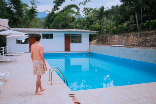Ein Mann steht neben einem Schwimmbad. in der Unterkunft Hotel Real Park in Tarapoto