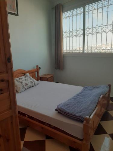 奥瑞尔agadir aourir plage appartement的房间里有一张床，窗户旁边还有一张床 sidx sidx sidx