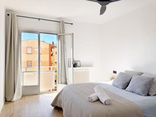 ein weißes Schlafzimmer mit einem Bett und einem großen Fenster in der Unterkunft Apartamento grande en Huesca in Huesca