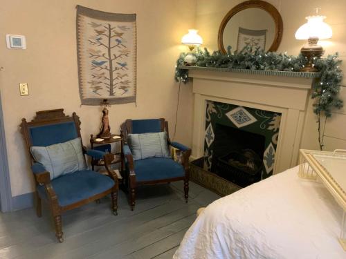 ein Wohnzimmer mit zwei Stühlen und einem Kamin in der Unterkunft Laura's Room in Jonesborough