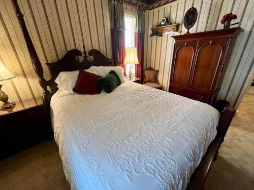 ein Schlafzimmer mit einem großen Bett mit roten und grünen Kissen in der Unterkunft Peter Miller's Room in Jonesborough