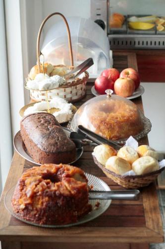 a table topped with different types of bread and apples at Pousada Casa Maré in Búzios