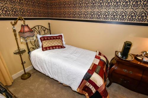 ein Schlafzimmer mit einem Bett, einer Lampe und einem Tisch in der Unterkunft The Tub Room in Jonesborough