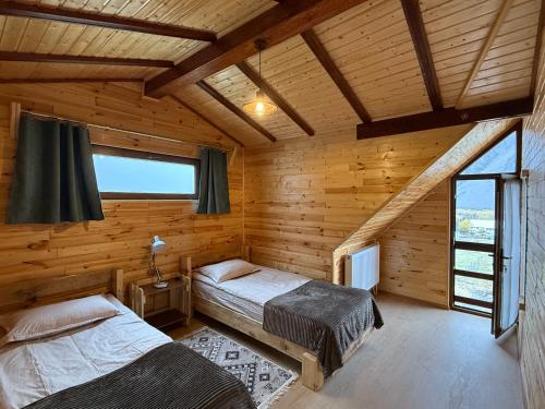 Un dormitorio con dos camas en una cabaña de madera. en old white house, en Kazbegi