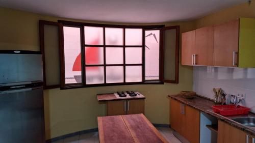 eine Küche mit einem Tisch und zwei Fenstern darin in der Unterkunft Kaza Manata in Praia
