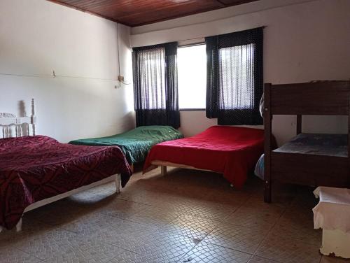 a room with two beds and a window at Pequeño Complejo Pachamama - Casa Aire in El Ceibal