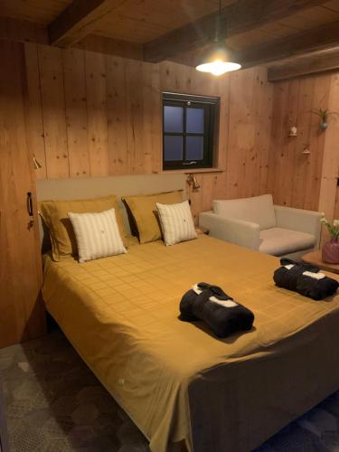 ein Schlafzimmer mit einem großen Bett und einer Couch in der Unterkunft Onder de Oude Walnoot in Sint Pancras