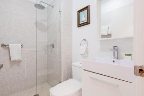 a white bathroom with a toilet and a sink at Arubas Life 303 in Noord