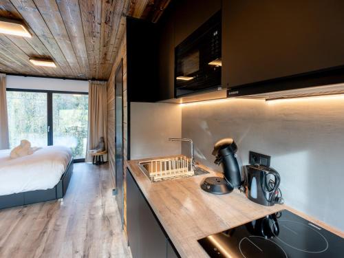 - une cuisine avec évier et un lit dans une chambre dans l'établissement ZenArden - Ninglinspo Valley view Lodge, à Aywaille