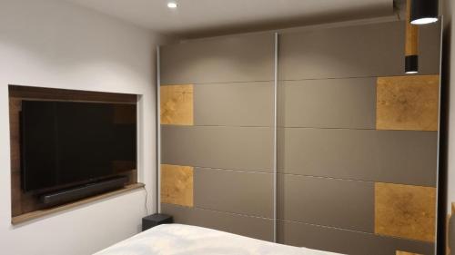 a bedroom with a wall mounted tv and a bed at Ferienhaus Strandschnecke in Dornumersiel