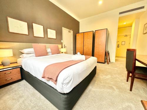 une chambre avec un grand lit et un bureau dans l'établissement Perfect City Pad in Heritage Complex, à Auckland