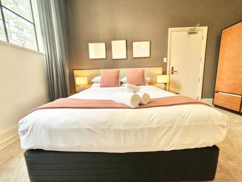une chambre avec un grand lit avec des serviettes dessus dans l'établissement Perfect City Pad in Heritage Complex, à Auckland