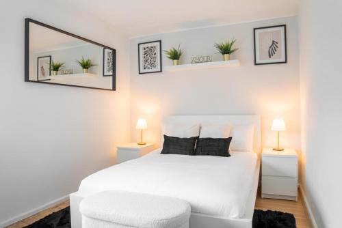 Un dormitorio con una cama blanca y una silla blanca. en Beautiful new build studio in London, en Sutton