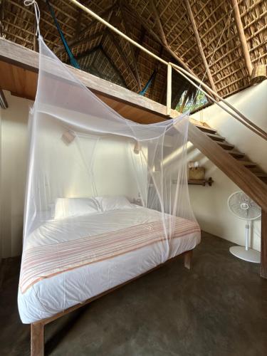 Bett in einem Zimmer mit Moskitonetz in der Unterkunft Casa Siddhartha in Mazunte