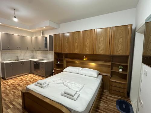 a bedroom with a large bed and a kitchen at Eyar house in Kamëz